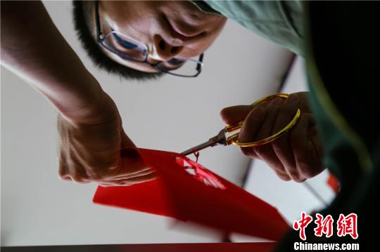 每一件作品的精雕细琢都离不开这把剪刀，一张彩纸、一把刻刀、一把剪刀、一双巧手，再加上一点创意，普通的宣纸经过他的一番改造，变幻成了一件件精美的纸艺作品。　裴海博　摄