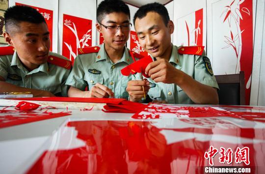 许多感兴趣的战友纷纷亲自体验剪纸工艺，续延征总是乐此不疲地给他们手把手传授。　裴海博　摄